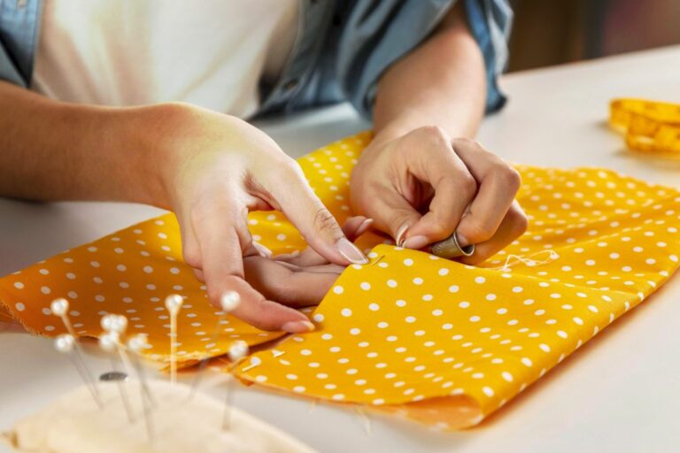 Couture à la main d'un tissu en coton jaune à pois blancs